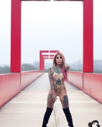 Обнаженная азиатка с татуированным телом позирует на мосту